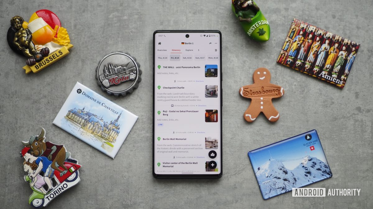Pixel 6 Pro on table showing Wanderlog travel planning app, with several city magnets next to it from Koln, Brussels, Amsterdam, and more.