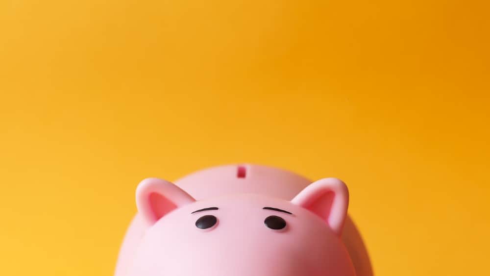 pink toy piggy money box on yellow background