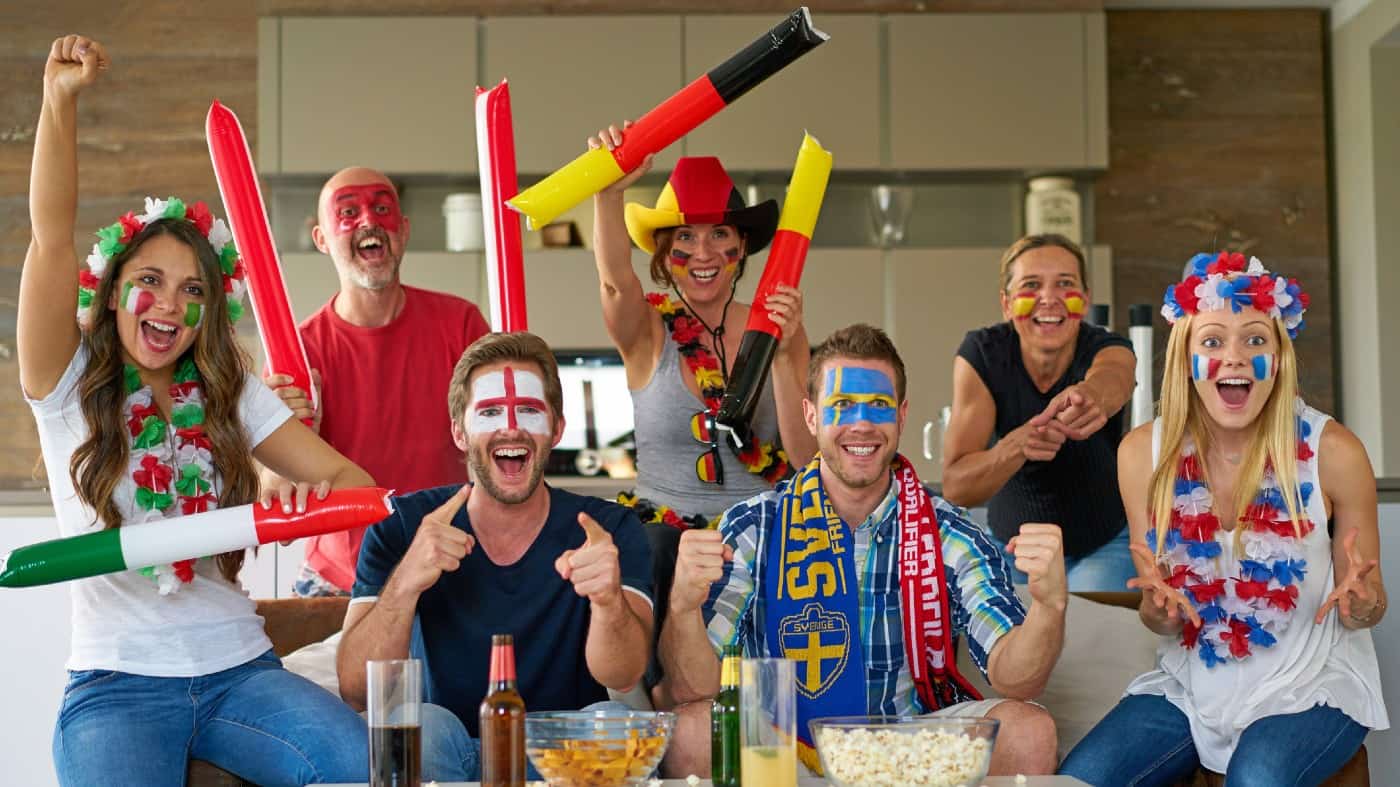 many happy international football fans watching tv