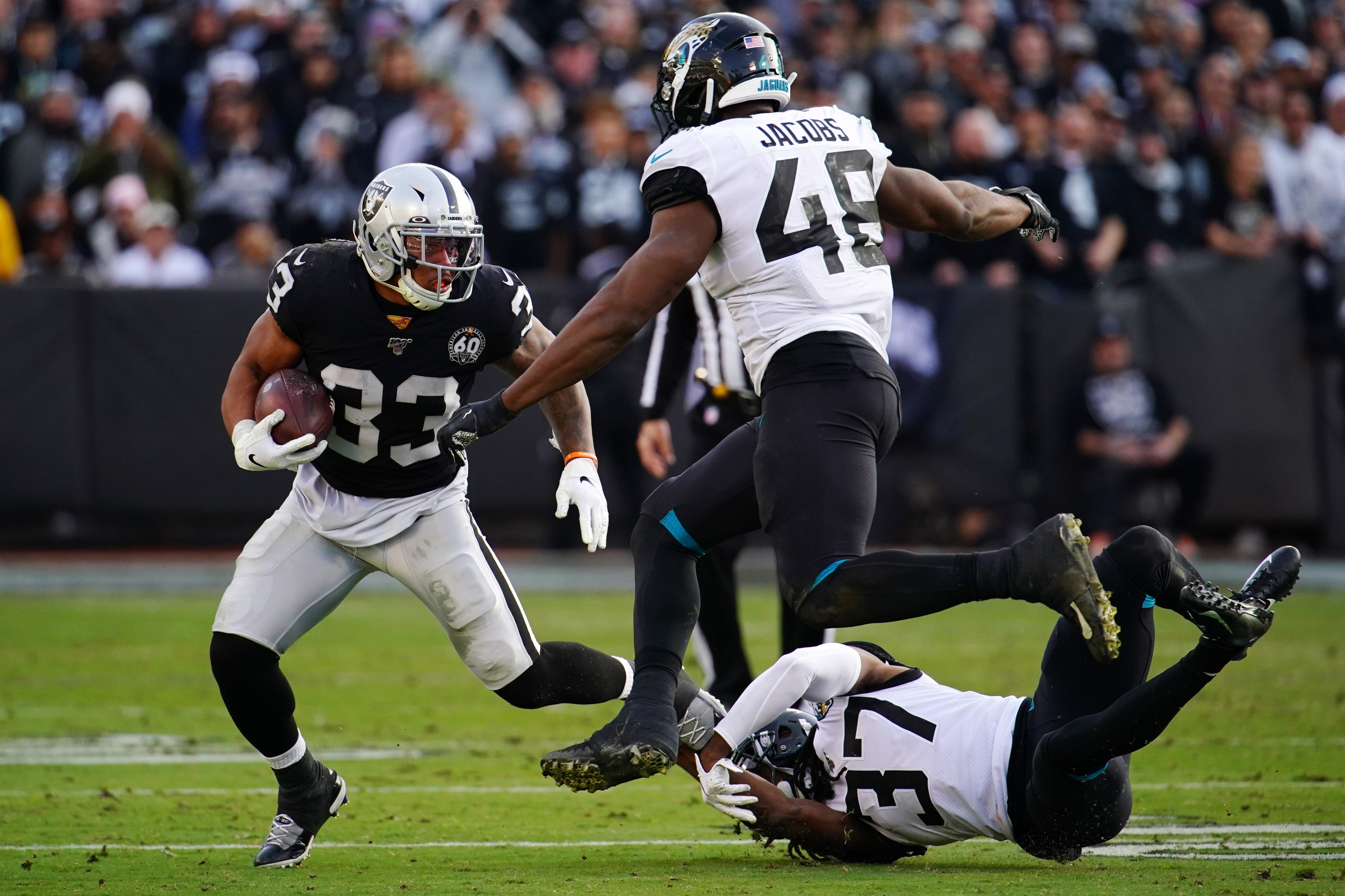 A Raiders player runs the ball in a game against the Jacksonville Jaguars