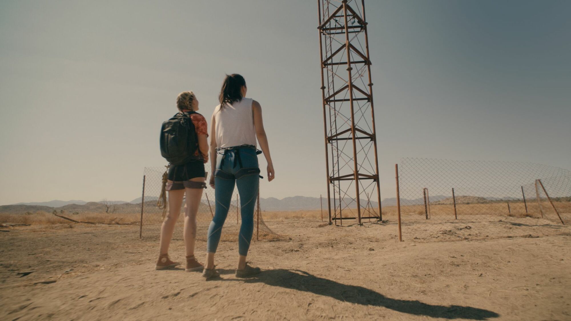 Virginia Gardner and Grace Caroline Currey stand before a tower in "Fall."
