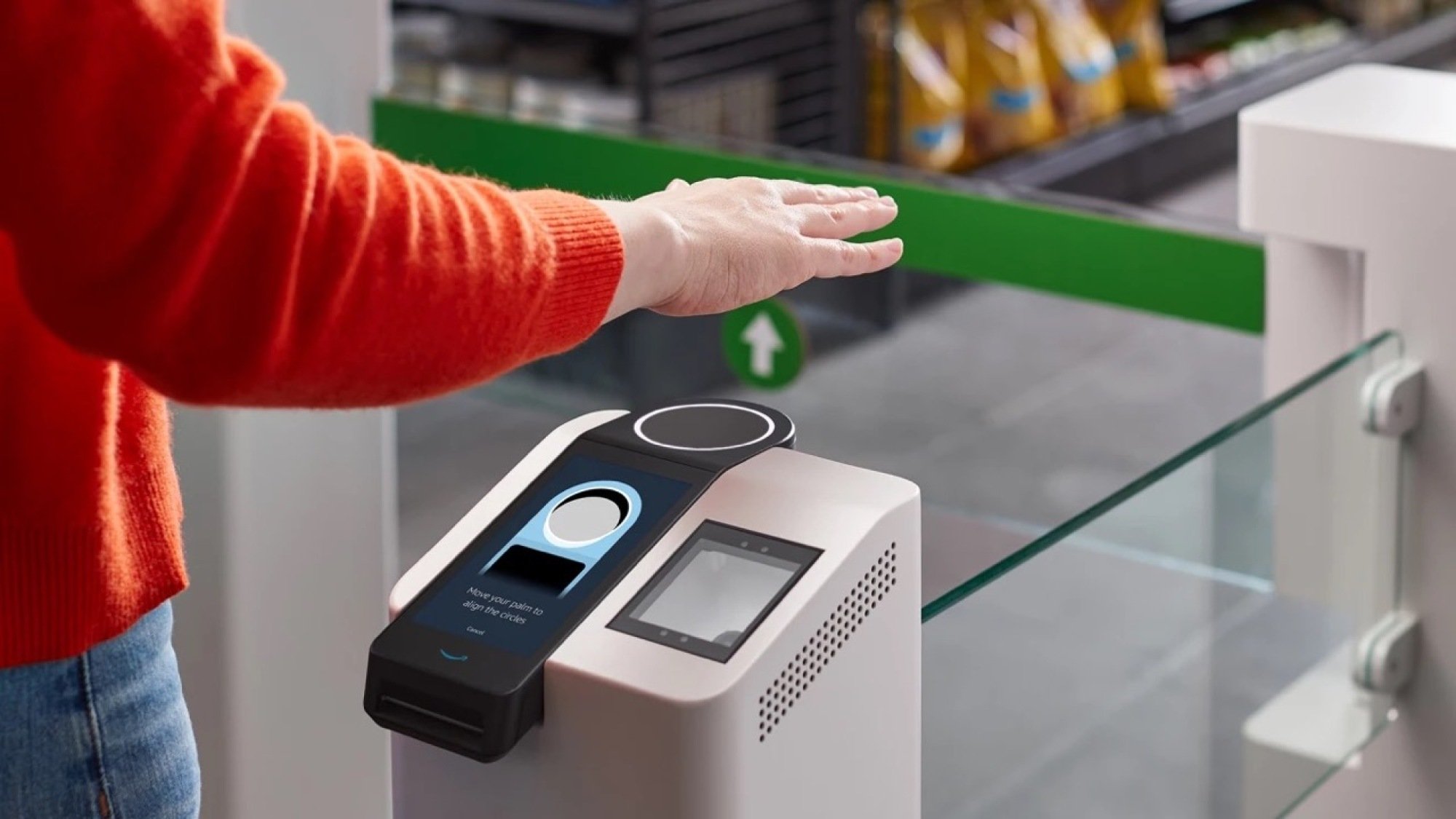Image of person hovering hand over Amazon One payment scanner