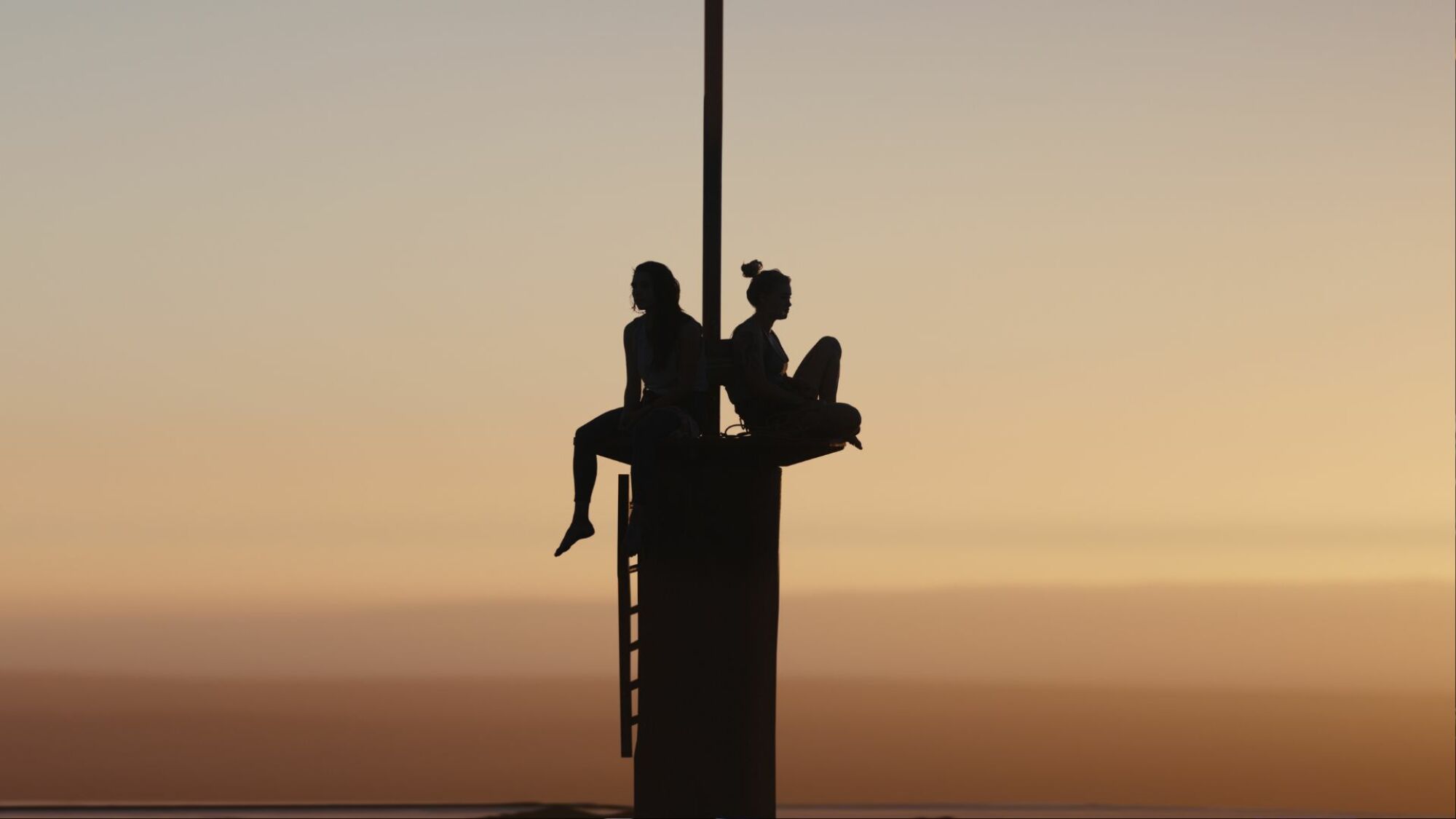 Virginia Gardner and Grace Caroline Currey sit atop a tower in "Fall."