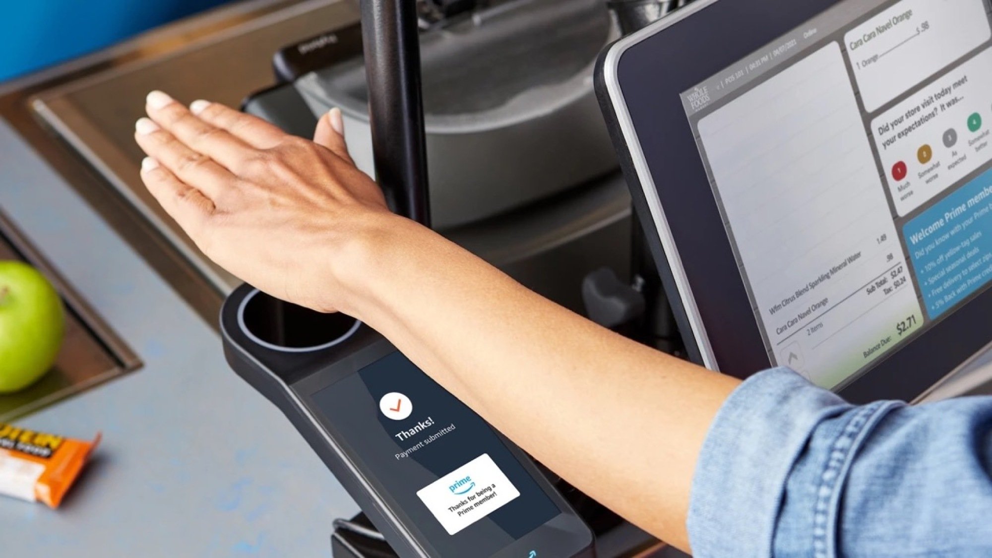 Image of person hovering hand over Amazon One scanner