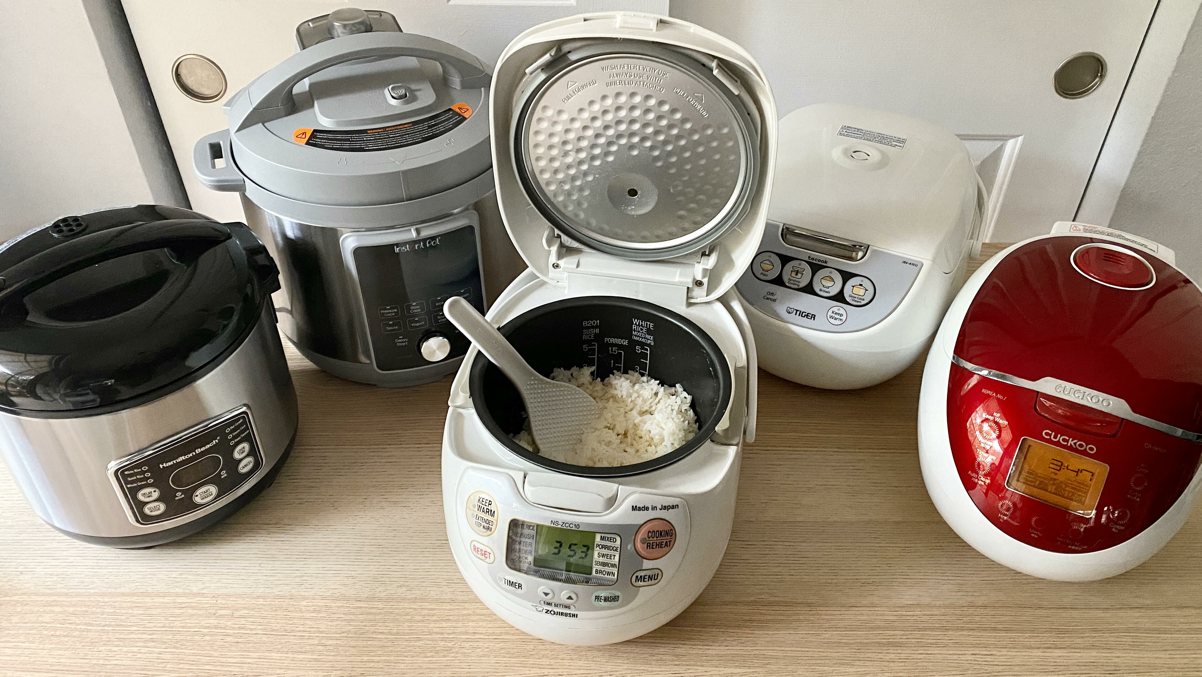 Five rice cookers on a table