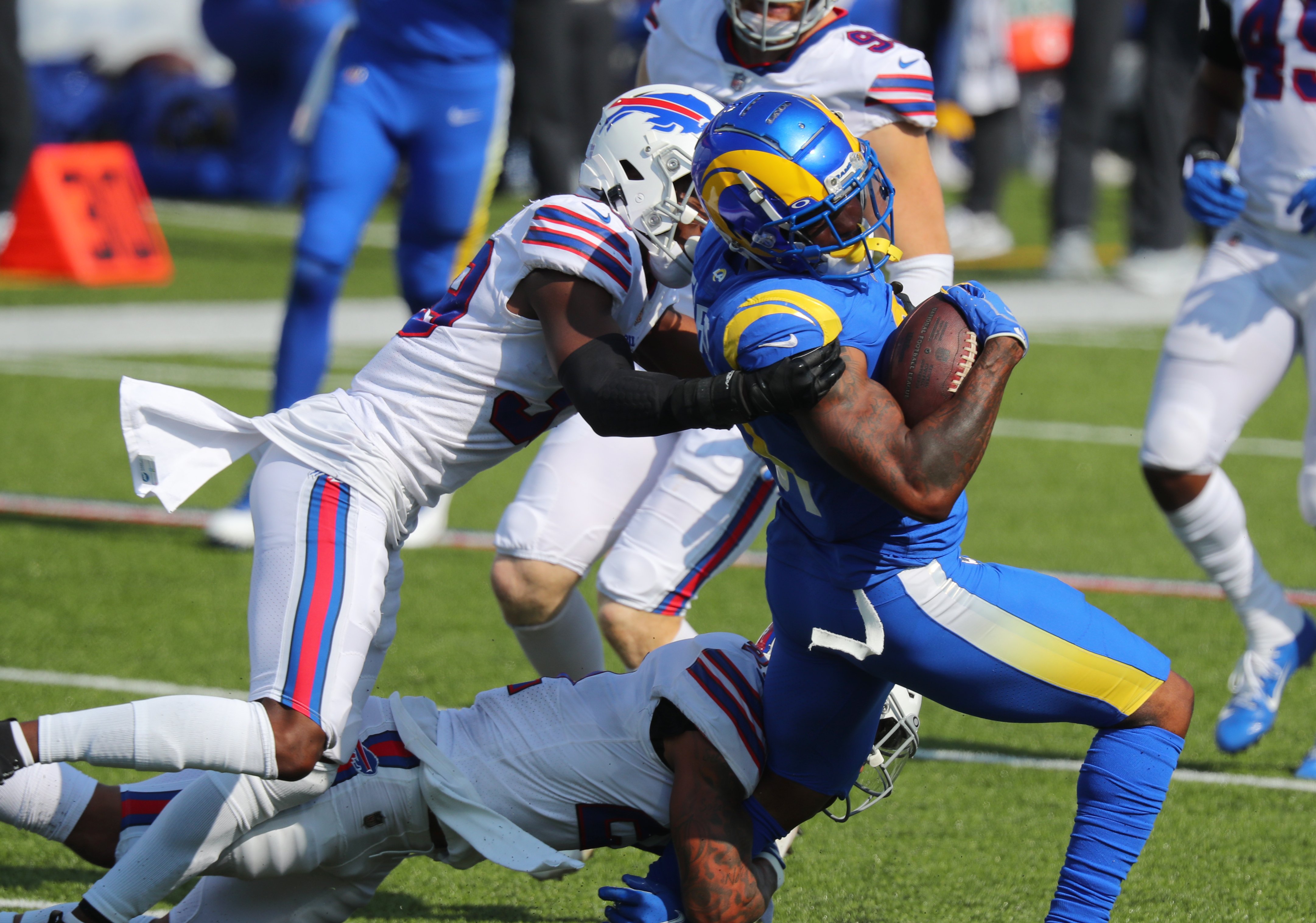 A Los Angeles Rams player is tackled by a Buffalo Bills player.