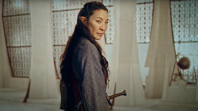 MIchelle Yeoh in the Witcher: Blood Origin standing with a sword in a white room 