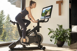 Woman on a stationary bike with a large screen