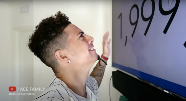 A screenshot of Austin McBroom staring at a large television screen watching his subscriber count hit 2 million.