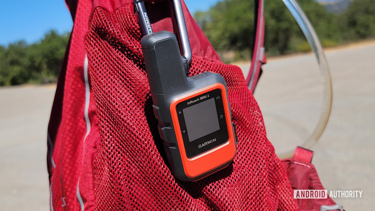 Garmin InReach Mini 2 strapped to a red hiking backpack