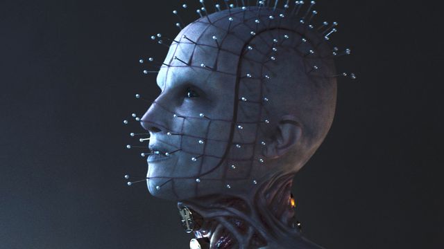 A close of up Jamie Clayton’s Pinhead aka the Priest in the new Hellraiser, with her skin peeling away being held up by pins