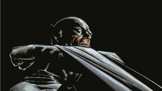 An illustration of Batman by artist Joe Quesada, depicting the character against a black background, dramatically raising up his cape below his chin as he faces the right side of the page.