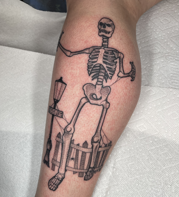 a fresh tattoo of a home depot skeleton on a woman's leg