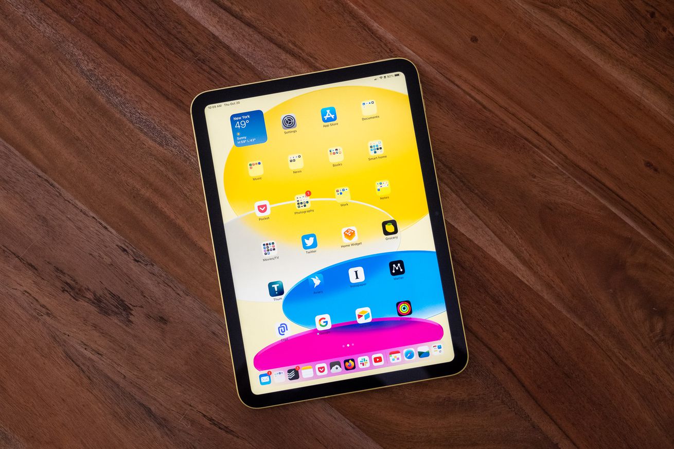 The 10th-gen iPad in yellow, resting face up on a wooden table.
