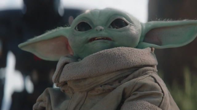 Grogu aka Baby Yoda looks up at an Imperial adversary in The Mandalorian