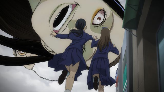 Two school girls running towards a giant face smiling and looking at them
