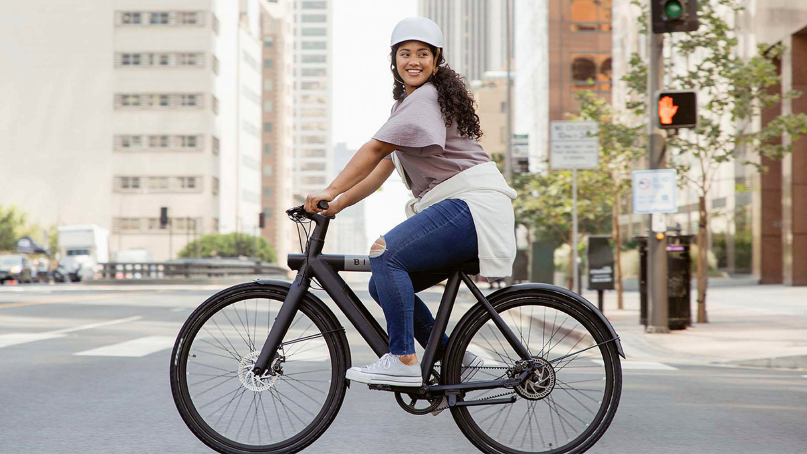 woman riding through city streets on bird electric bike
