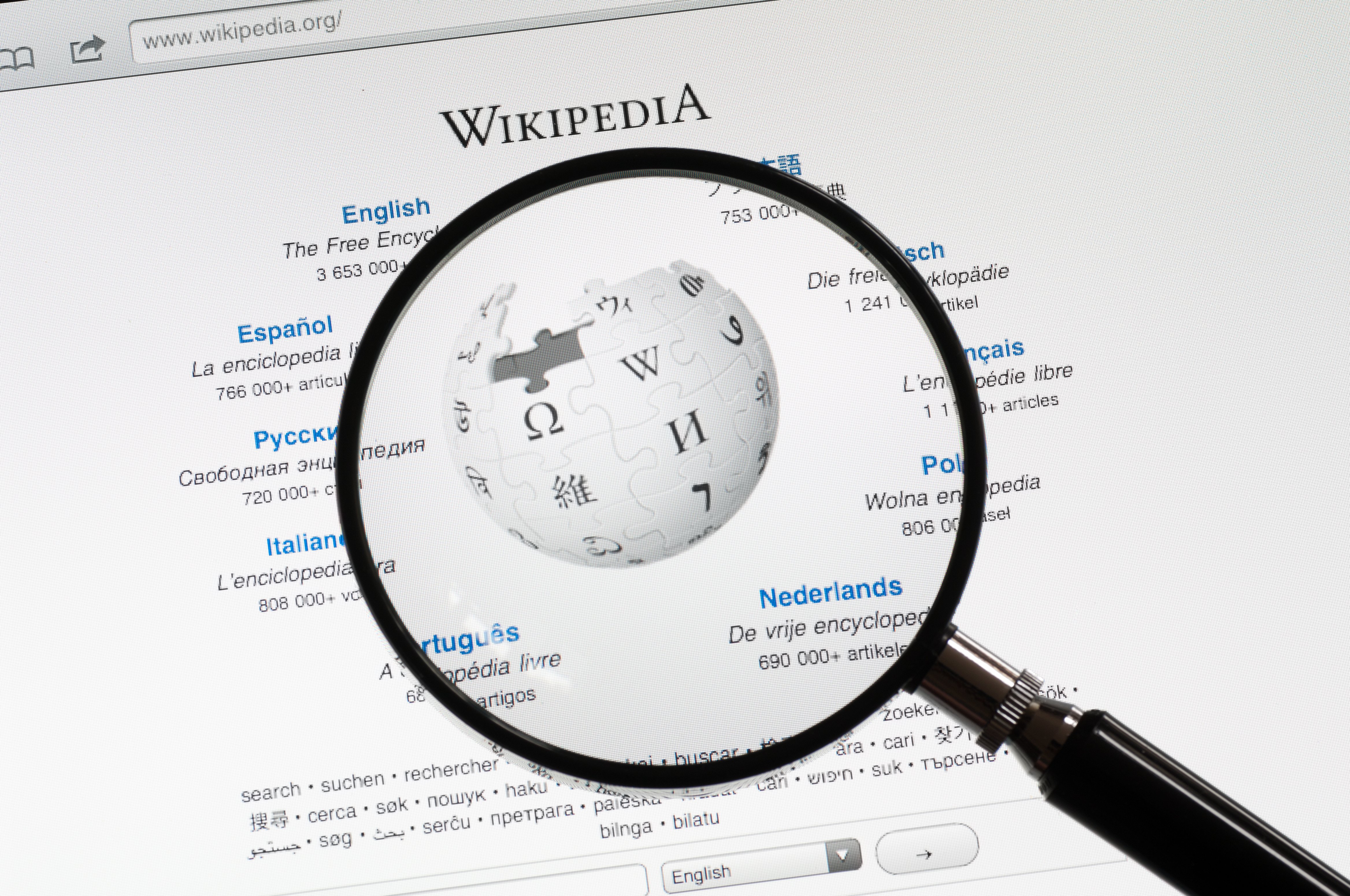 The Wikipedia homepage seen through a magnifying glass